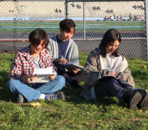 (From left to right) Freshman Alyx Chow, senior Erin Morales and sophomore Melinda Qerushi sit and write.