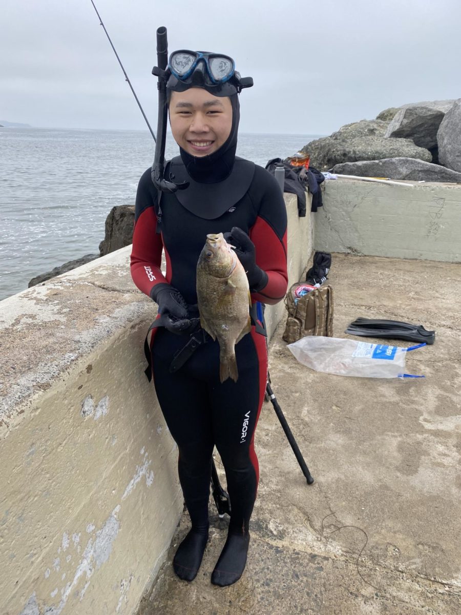 Senior Andrew Qi holds up a fish he caught. 