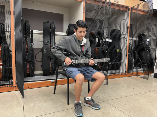Guitarist freshman Miles Nguyen practices his guitar in anticipation of his coach.