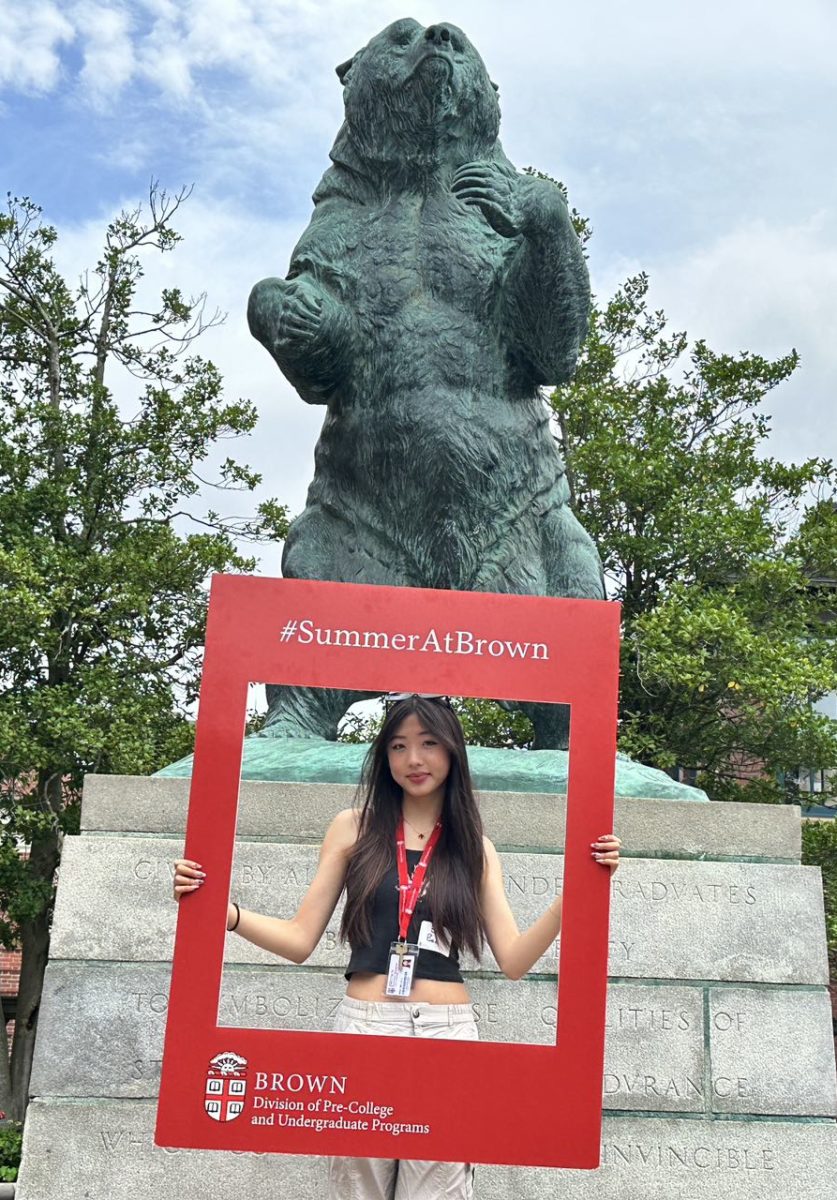 Senior Belle Bao takes a picture in front of Brown’s mascot during her summer program.