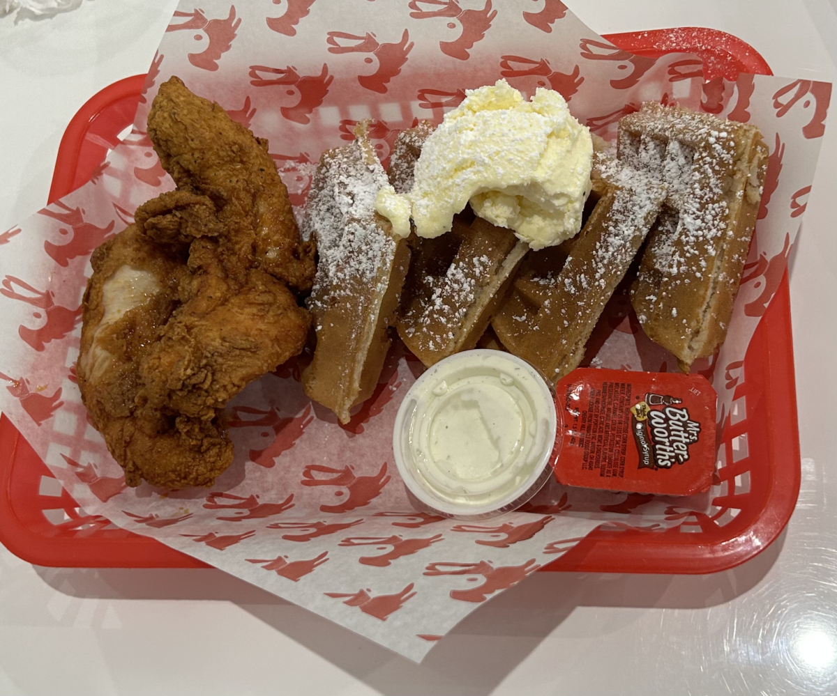 Featured is Crimson fried chicken and waffles topped with butter and powdered sugar.