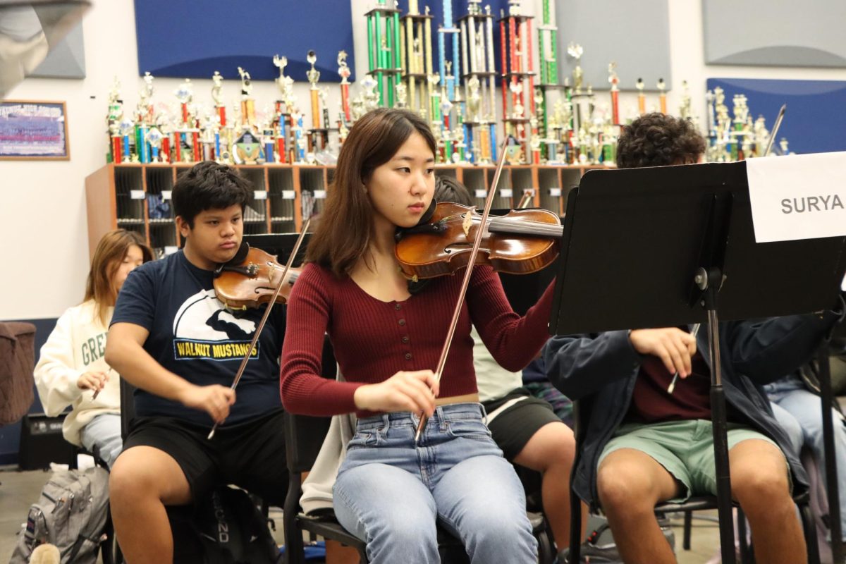 Senior Dory Kawauchi prepares for orchestra’s Winter Concert. “Music has always been a big part of my life and the orchestra really helps bring all the different musicians together to work on some common goal and to perform to the public,” Kawauchi said. 