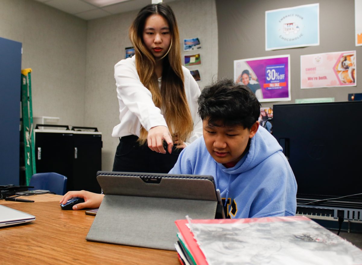 Senior Mary Wang and junior Joshua Husain discuss their design for the new pamphlets for the Ron Hockwalt Academies. “I was kind of frustrated because during this time, we had a lot of ideas that were clashing with each other,” Husain said. 