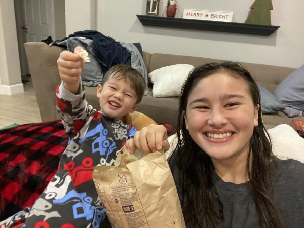 Sophomore Avie Lin eats popcorn with the child she babysits.