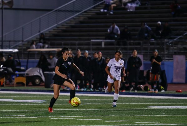 Sophomore attacking midfielder Gracie Baird dribbles the ball away from the defender. 