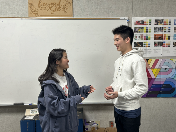 Senior Zoey Tran discusses with club president junior Ryan Huang about potentially buying merchandise for his club. 