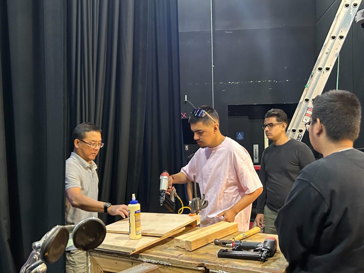 Stagecraft students (from left to right) seniors Matthew Segura, Antonio Ron and Kai Ho assist Mr. Yamashiro in building a set piece for the show.