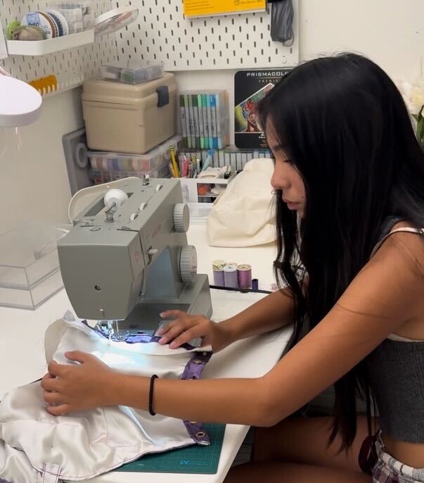 Junior Jaedlyn Arzadon sews the pieces of fabric together for her homecoming dress.