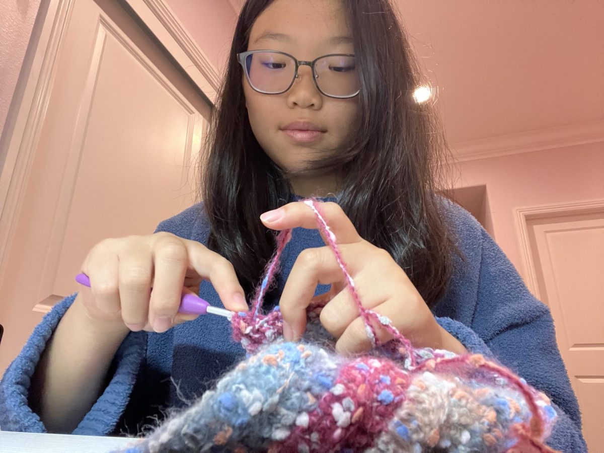 Junior Angelina Tuang carefully crochets with colorful yarn. 