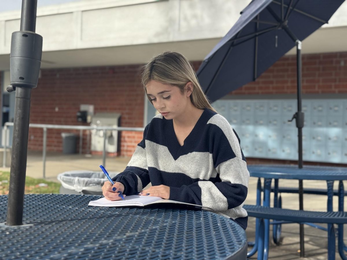 Drawing to life | Senior Mia Arias focuses as she sketches in her notebook. “I have a passion for drawing old people and stuff like that. I like it when people say that they look alive,” Arias said. 