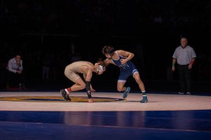 Dominating the mat | Senior Ronnie Ramirez (right) clubs his opponent (left), a common but effective move that involves striking with the elbow to set up a throw or a hold, in a win at the 2024 CIF state finals match in Mechanics Bank Arena.  “During the match, I was pretty nervous, but not a lot because I had so much adrenaline in me. This match means a lot to me because the state championship was the end goal, and it felt good to be there in front of everyone.” 