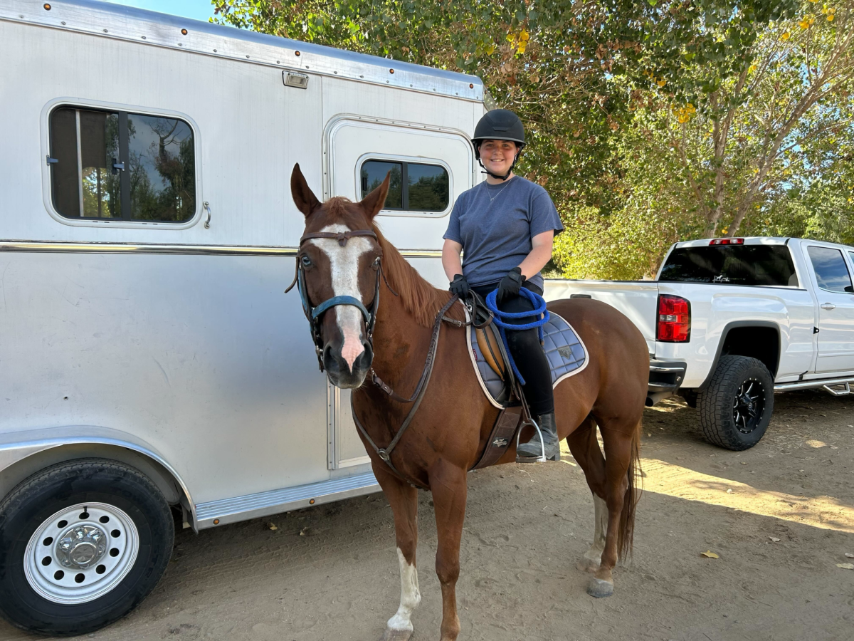 Freshman Avery Bromberg gets ready to practice jumping hurdles with her horse, Blue. “It was fun [to start jumping] from the beginning because my trainer won’t let you start at the top, she’ll make you go all the way down,” Bromberg said. 