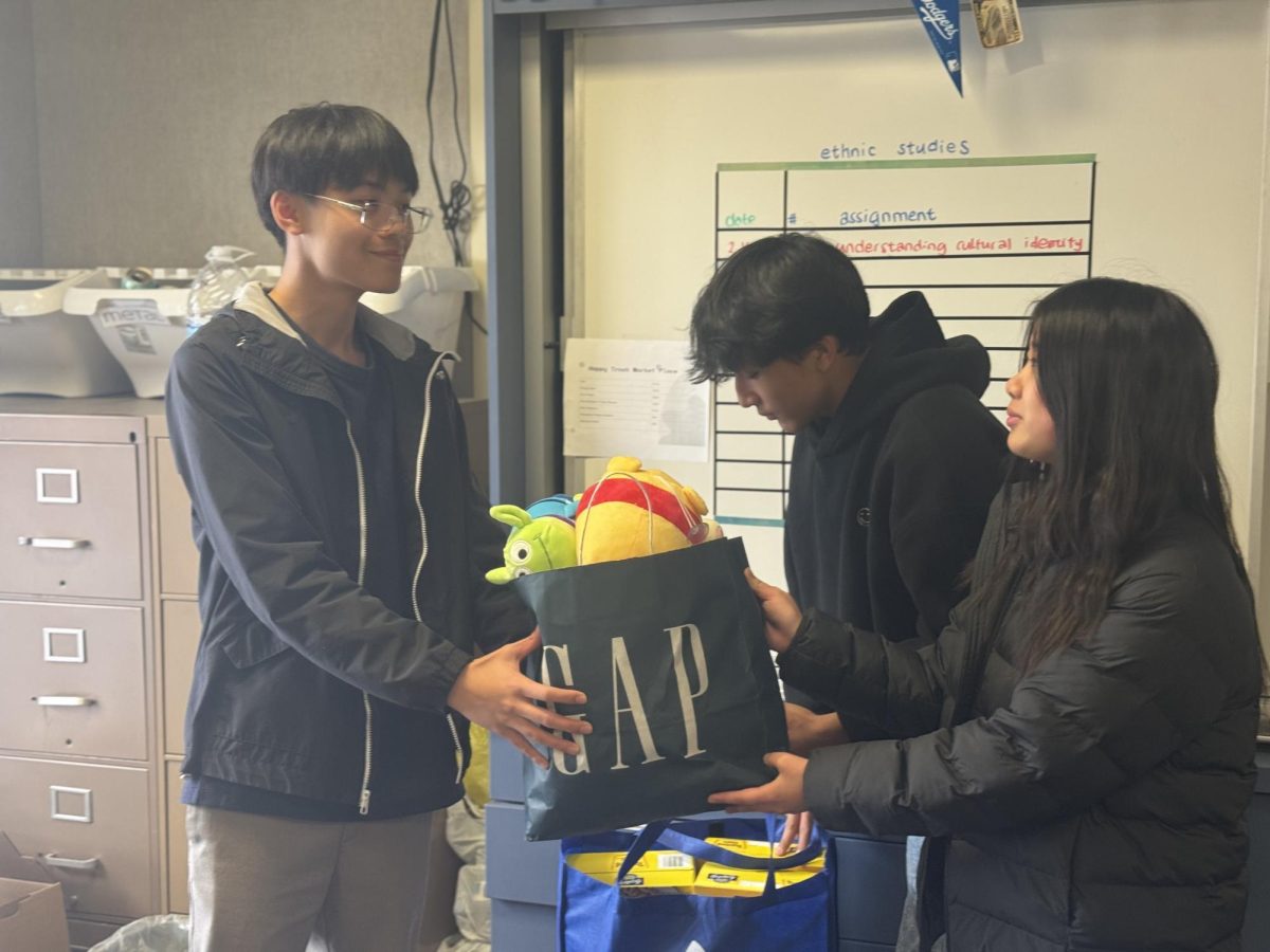 Collective efforts | Gardening Club president junior Conan Yu collects a donation of stuffed animals from a student. “It’s a great thing that we’re supporting the families that have been hurt or harmed in these fires, and that we’re providing any type of aid to them,” Yu said. 