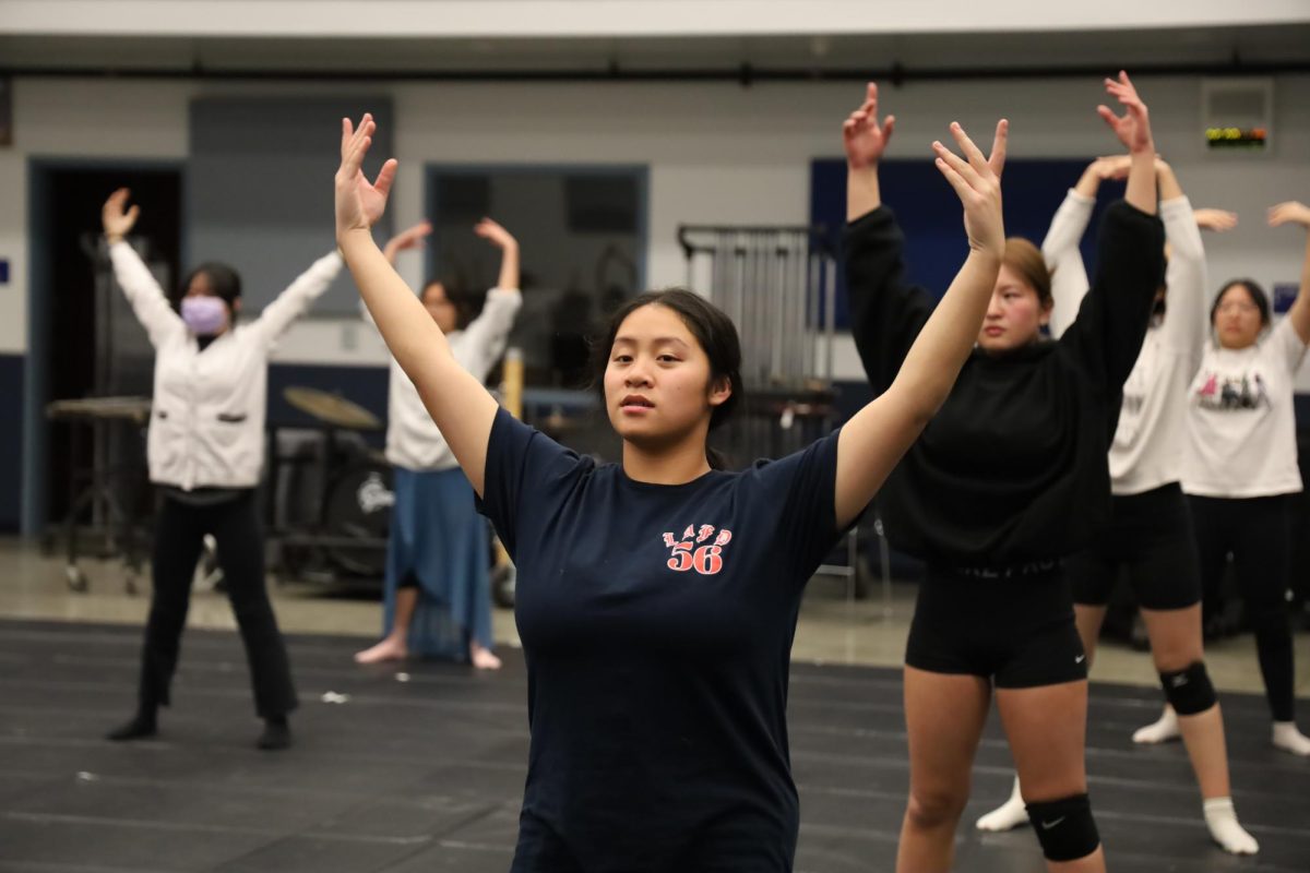 Go with the flow | Winter Guard captain senior Amanda Chan leads pre-practice stretches for her team. 