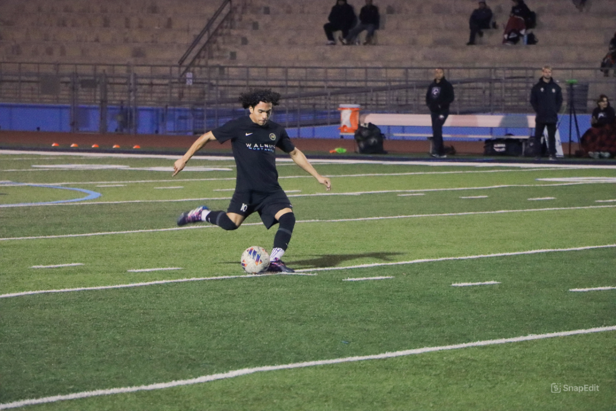 Playing offense | Midfielder senior Christian Garcia kicks the ball up the field against Glendora in a 5-0 home win. 