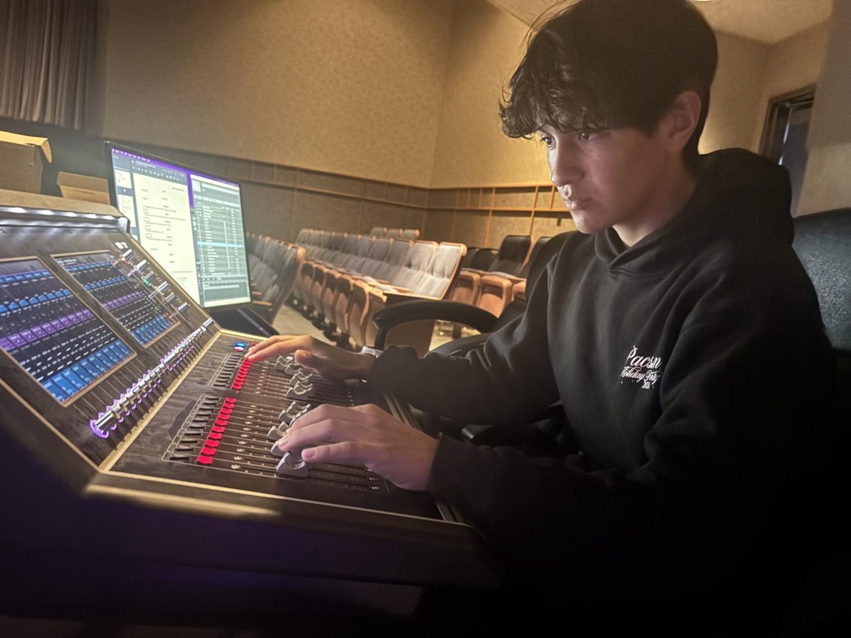 Sophomore Logen Behar manages the controls of an audio mixer.