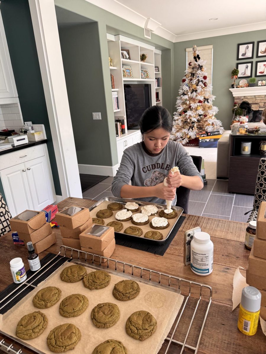 Freshman Victoria Hsu squeezes frosting onto her newly baked batch of cookies. 