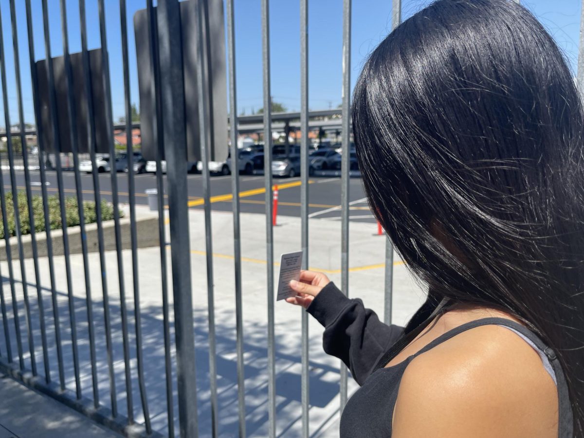 Using her sixth period sticker, senior Hazel Li uses her ID to exit campus.