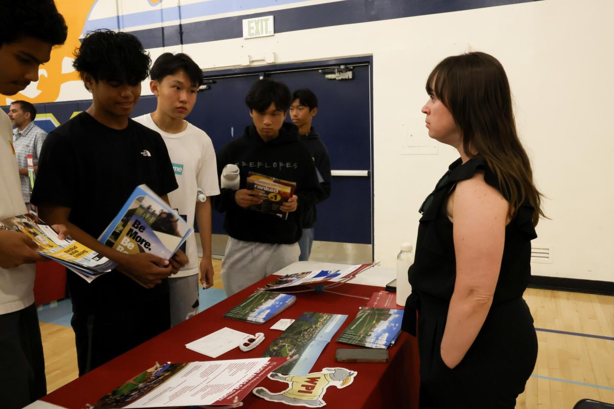 Juniors Justin Abellera and Ryan Wang and sophomore Dylan Toh talk to a representative from Worcester Polytechnic Institute. “Grant cuts will likely impact my tuition. If the university can’t afford to run their school because of funding cuts, they may pass it over to me to pay. While Worcester looked pretty convincing as a polytechnic university, the $80,000 price tag to attend makes me more hesitant to go there,” Abellera said.