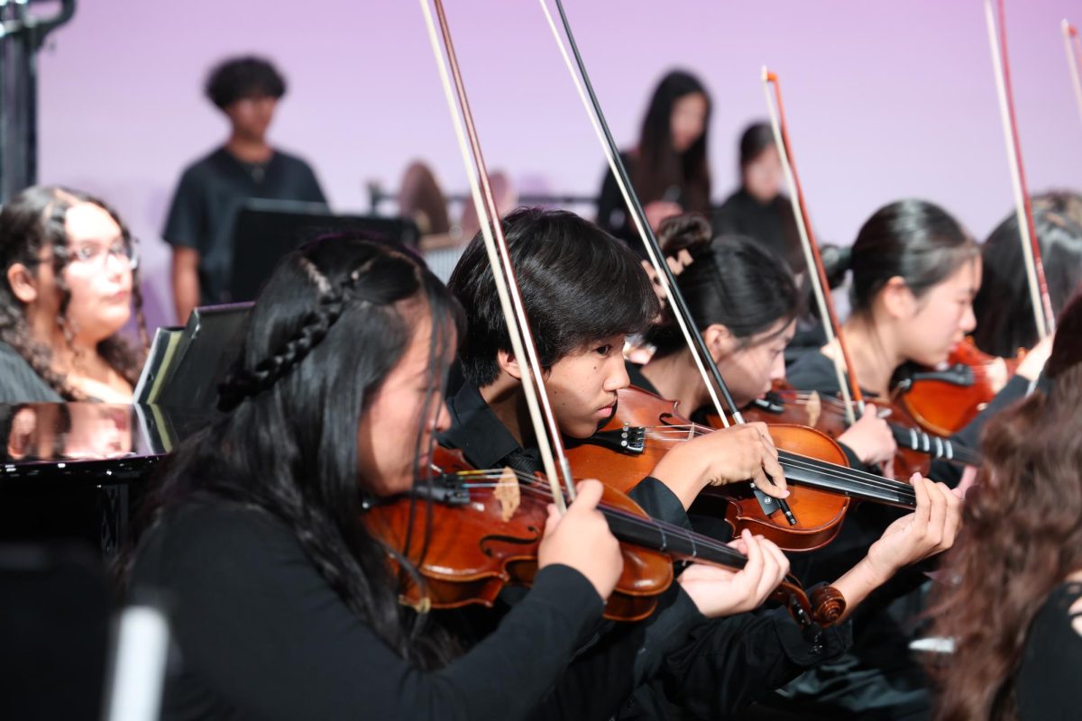 Sophomore Ethan Zhang gets ready to play the violin after a few measures of rest.