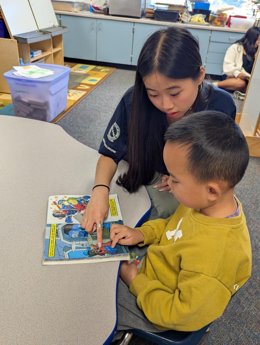Senior Cara Cheung helps out elementary students.