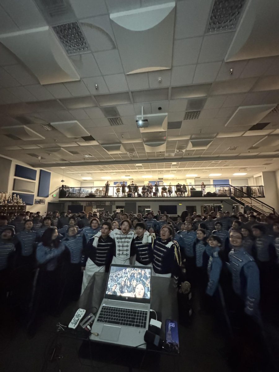 Marching band huddles up for their tradition of watching videos compiled with photos.