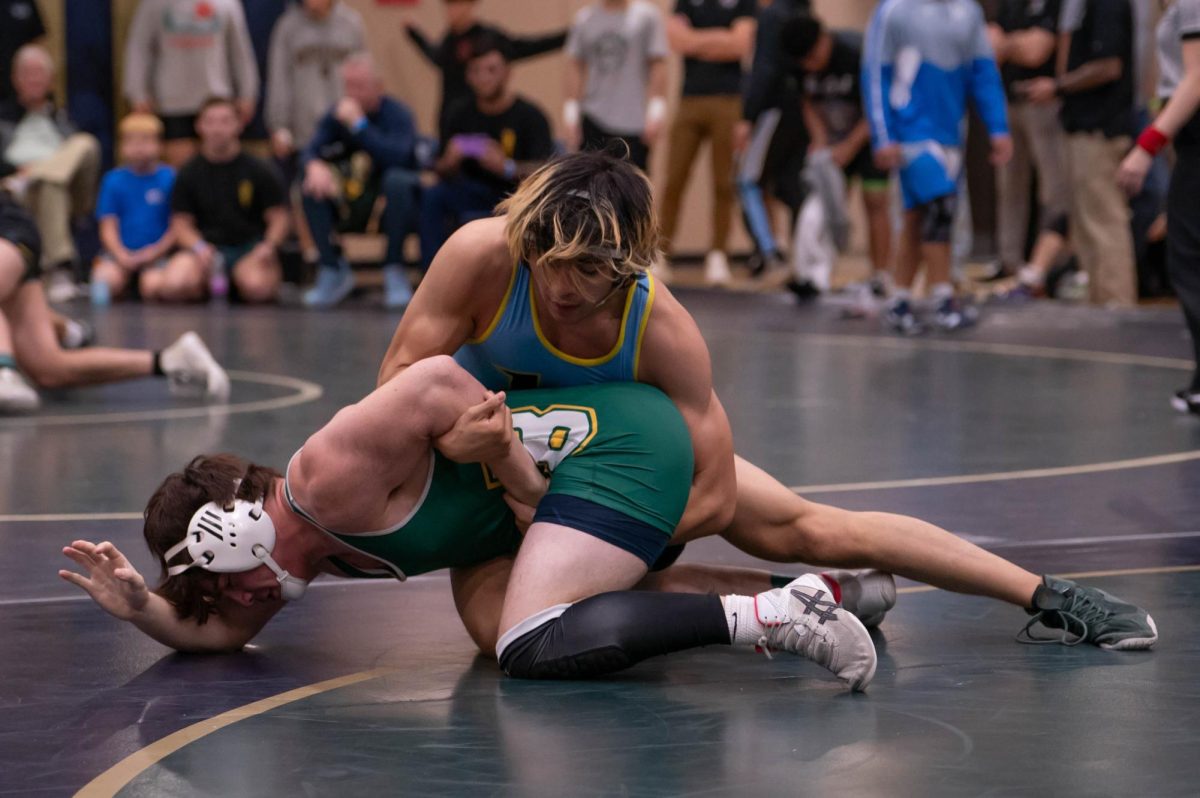 Senior Brady Williams flips his opponent over and pins him during a match. 