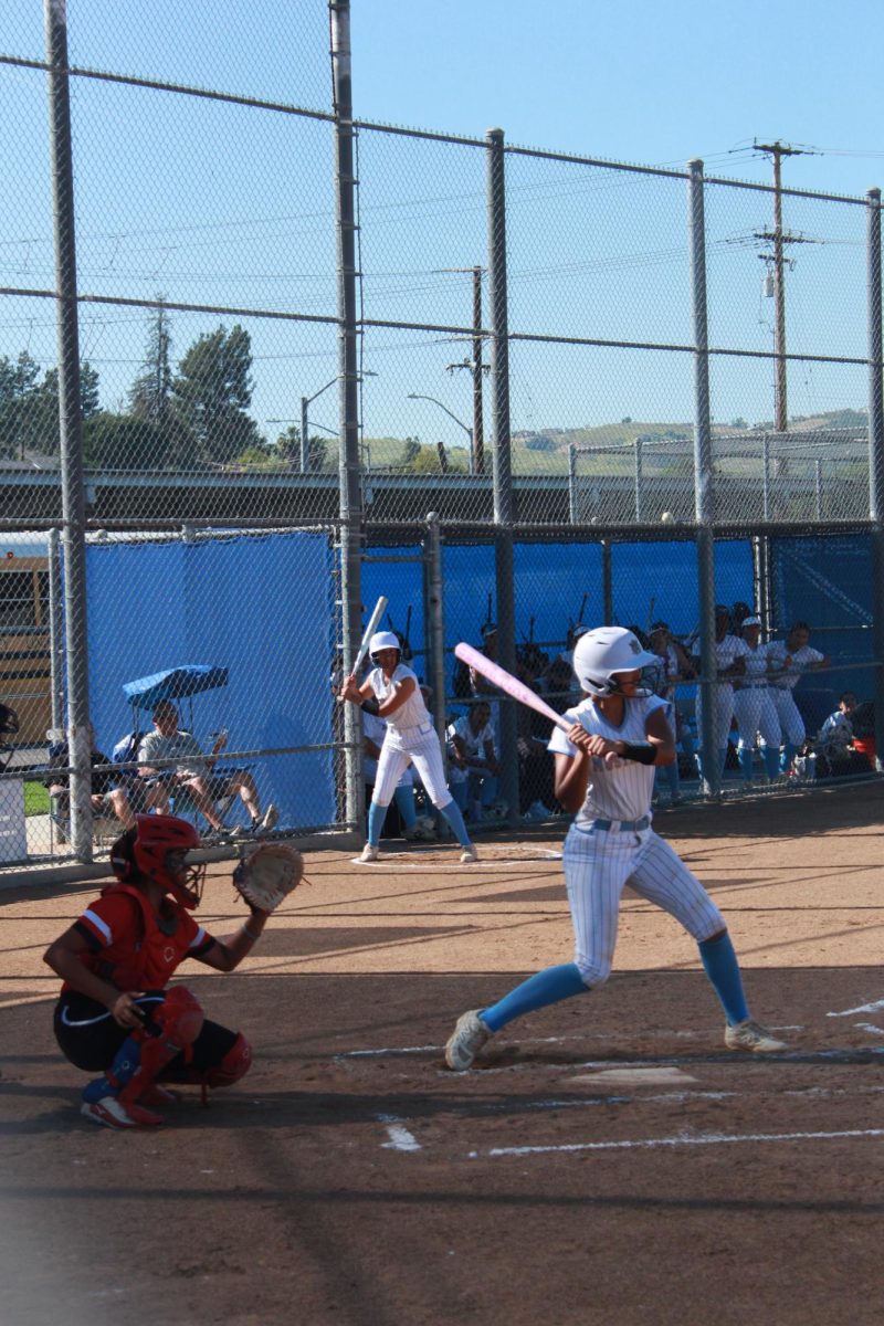 Swinging start | Varsity Catcher junior Kaitlyn McGill is in the middle of swinging.