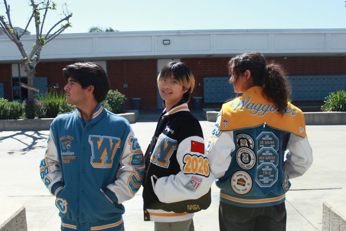 Prints, patches and the past | From left to right, seniors Jonathan Castellanos, Yangyang “Coco” Chen and Ava Waggoner sport their letterman jackets with the many patches they’ve earned throughout their athletic journey. (Photo by Lucas Lim)