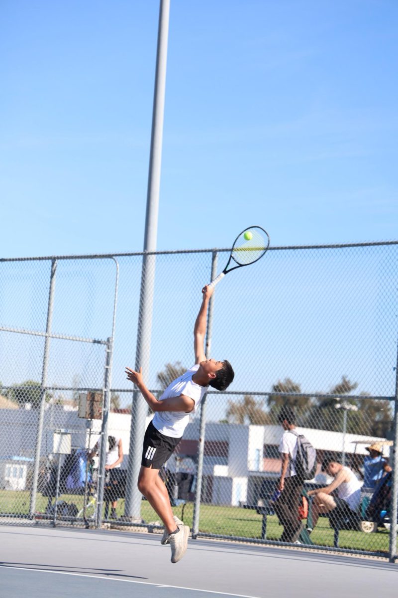 Starting serve | Junior David Liu begins his singles match with a serve. (Photo by Summer Do)