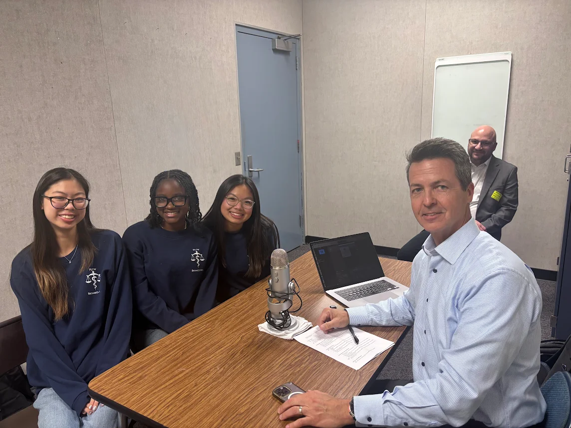 From left to right, Danika Pe (10), Dymond Dolberry (11), Canise Lee (12) and CEO David Dimmett pose for a photo after the three students were interviewed for a podcast.