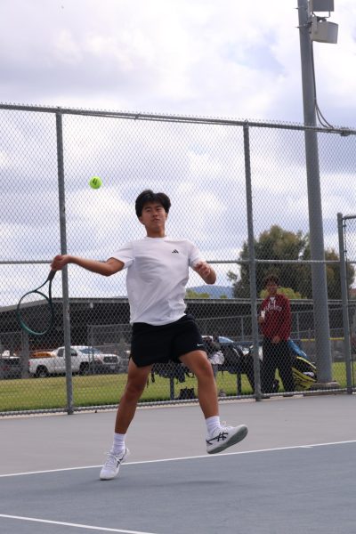Singles junior Brad Wong swings his racket to hit the ball. "During the moment, I felt pretty confident that my shot was going to go in," Wong said. 