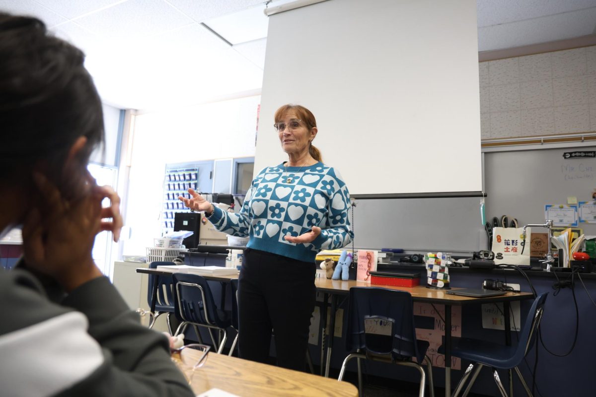 Biology teacher and International Baccalaureate coordinator explains a biology concept to her biology class. 