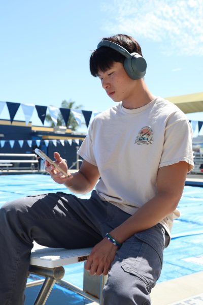 Senior Kyle Lin scrolls through his Spotify playlist to prepare mentally for practice. "[Music] helps me get to a good vibe or mood and it helps me prepare mentally for my race or just practice," Lin said.